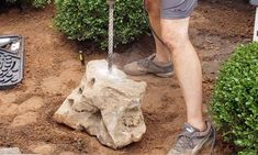 a man standing on top of a rock next to a fire hydrant in the dirt