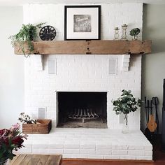 a living room with a white brick fireplace and potted plants on the mantel