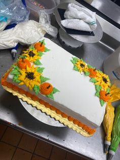 a cake with sunflowers on it sitting on top of a counter next to a knife