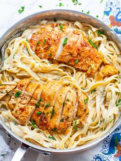 chicken and pasta in a pan with parsley on the side, ready to be eaten