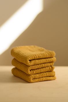 four yellow towels stacked on top of each other