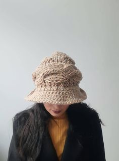 Fashionable knitted cloche. Classic headwear. Cloche hat in the style of the 1930s. Stylish fashionable hat for everyday use. A warm cap with a brim on a fleece lining. Cloche hat in the style of the 1930s for women. Knitted winter hat is available in 36 colors.  The color in the photo may vary slightly depending on the settings of your computer monitor.  If you need a special color please send me a private message. I will make you a hat of the desired color in 1-3 days. Nice comfortable hat mad Beige Hand Knitted Winter Hat, Beige Crochet Hat For Fall, One Size Fits Most, Cozy Beige Knit Crochet Hat, Fall Beige Crochet Hat, Cozy Beige Crochet Knit Hat, Winter Knitted Brimmed Cloche Hat, Knitted Cloche Hat With Curved Brim For Winter, Brimmed Beige Winter Bonnet, Adjustable Knitted Cloche Hat