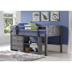 a bunk bed with drawers underneath it and blue walls in the background, along with a rug on the floor