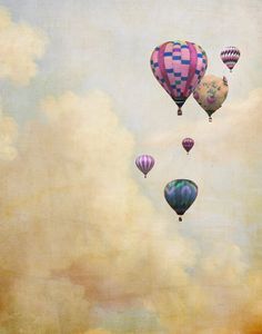 three hot air balloons flying in the sky with clouds behind them and one balloon floating above it