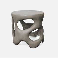 a small table with an unusual design on it's top and bottom, made out of concrete