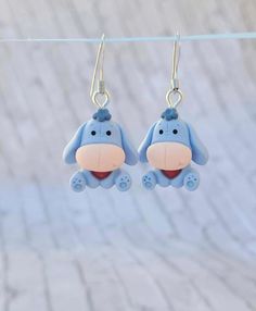 small blue dog shaped earrings hanging from a clothes line