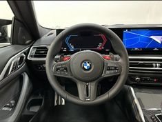 the interior of a bmw vehicle with an electronic display and steering wheel control, including touchscreens