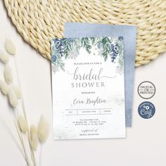 a blue and white bridal shower card on top of a table next to some flowers