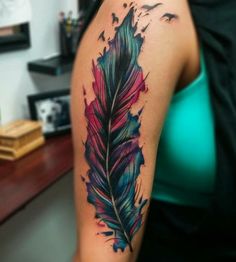 a colorful feather tattoo on the arm