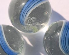 three glass balls with blue bands on them