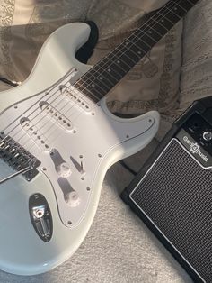 an electric guitar and amp sitting on a bed