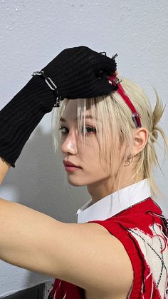 a woman with blonde hair and black gloves