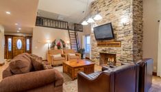 a living room filled with furniture and a flat screen tv mounted on the wall above a fireplace