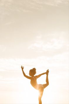 a woman standing on top of a surfboard in the ocean while holding her arms out