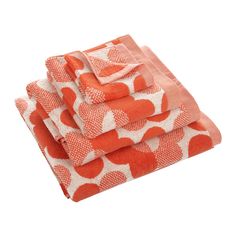 four towels folded on top of each other in an orange and white pattern with hearts