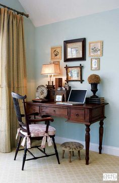 a desk with a laptop computer on top of it next to a chair and lamp