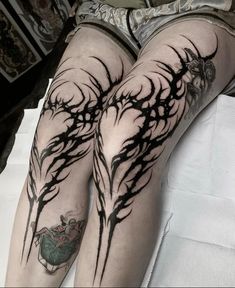 the legs are covered in black ink and have trees on them with leaves growing out of them