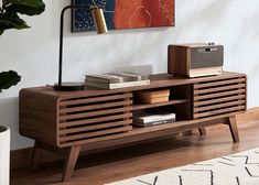 a living room with a wooden entertainment center on top of a hard wood floor next to a painting