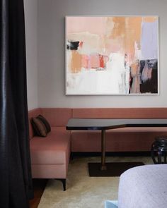 a living room filled with furniture and a painting on the wall