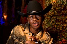 a man wearing a black cowboy hat and gold shirt