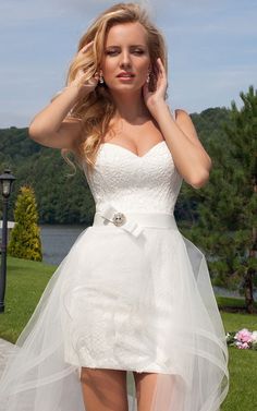 a woman in a short white dress posing for the camera