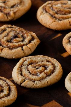 several cinnamon rolls are on a wooden table