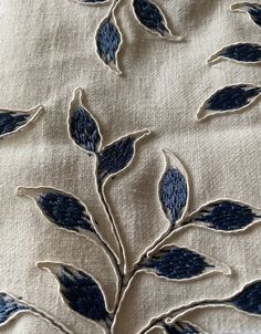 an embroidered fabric with blue leaves on it