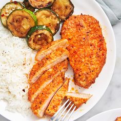 a white plate topped with chicken, rice and zucchini