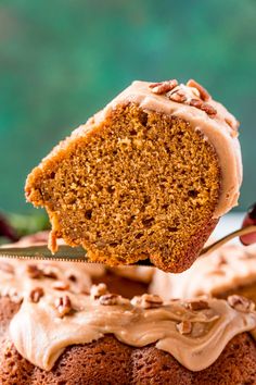 a close up of a piece of cake with frosting and nuts on the top