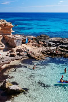 people are swimming in the clear blue water