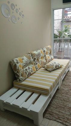 a couch made out of pallets in front of a window