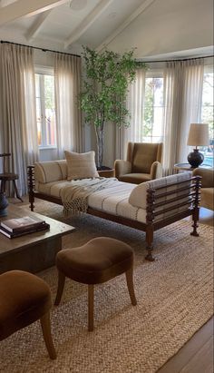 a living room with couches, chairs and a coffee table in front of two windows