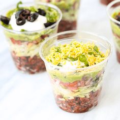 four plastic cups filled with different types of food