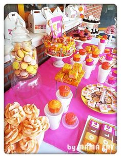 a pink table topped with lots of desserts