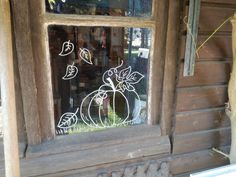 a window that has some drawings on the side of it in front of a house