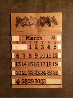 a wooden calendar with horses and numbers on it