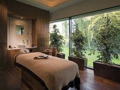 a spa room with a large window looking out onto the golf course and trees outside