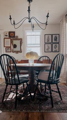 a dining room table with four chairs and a chandelier hanging from the ceiling