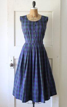 Classic vintage 1950s navy and dark green plaid cotton jumper dress. Made of a soft cotton with a polka dot pattern woven into the textile. Featuring a scoop neckline, functional fabric covered buttons down the front, fitted waist, and full pleated skirt. Has a metal side zipper and belt loops. Would look great styled with a long sleeve blouse beneath. ☾ Info ☽ Material: cotton Label: A David Crystal Fashion Condition: very good vintage condition; I've repaired a 1" rip at the back of the neck and a pea sized rip near the left underarm Freshly laundered and ready to wear! ☾ Measurements ☽ Fits like: small Bust: 34" (can stretch to 35") Waist: 26" Hips: free Length (from shoulder): 45" Bodice length (from shoulder): 16"  *shown unpinned on a 33" bust, 25" waist dress form  ☾ More vintage dr Green Plaid Dress, Crystal Fashion, Cotton Labels, Cotton Jumper, 50s Dresses, Fabric Covered Button, Navy Green, Dress Form, Polka Dot Pattern