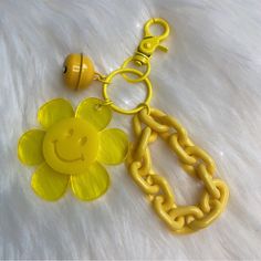 a yellow keychain with a smiley face on it and a chain attached to it