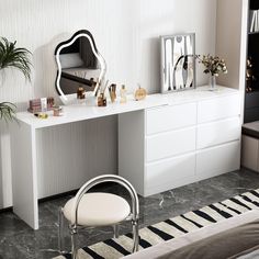 a white desk with a mirror, stool and plant on it next to a bed