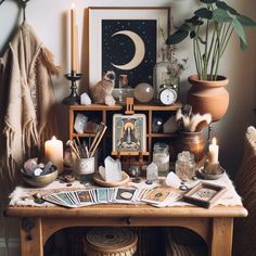 a wooden table topped with lots of items next to a shelf filled with candles and pictures