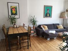 a living room filled with furniture next to a wooden floor covered in lots of plants