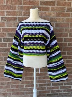 a white mannequin with a green and black striped sweater on top of it