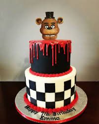 a three tiered cake decorated with a bear head and checkered pattern on top