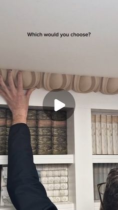 a man is reaching up to the ceiling in front of bookshelves with words which would you choose?