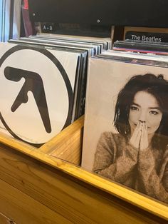 several records are stacked on top of each other in front of a shelf with pictures