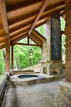 an outdoor hot tub in the middle of a covered patio with stone walls and pillars