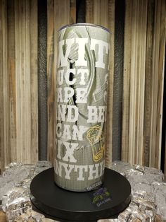 a can of beer sitting on top of a table next to some ice cubes