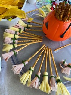 halloween treats are arranged in the shape of pumpkins and bats on sticks with toothpicks sticking out of them